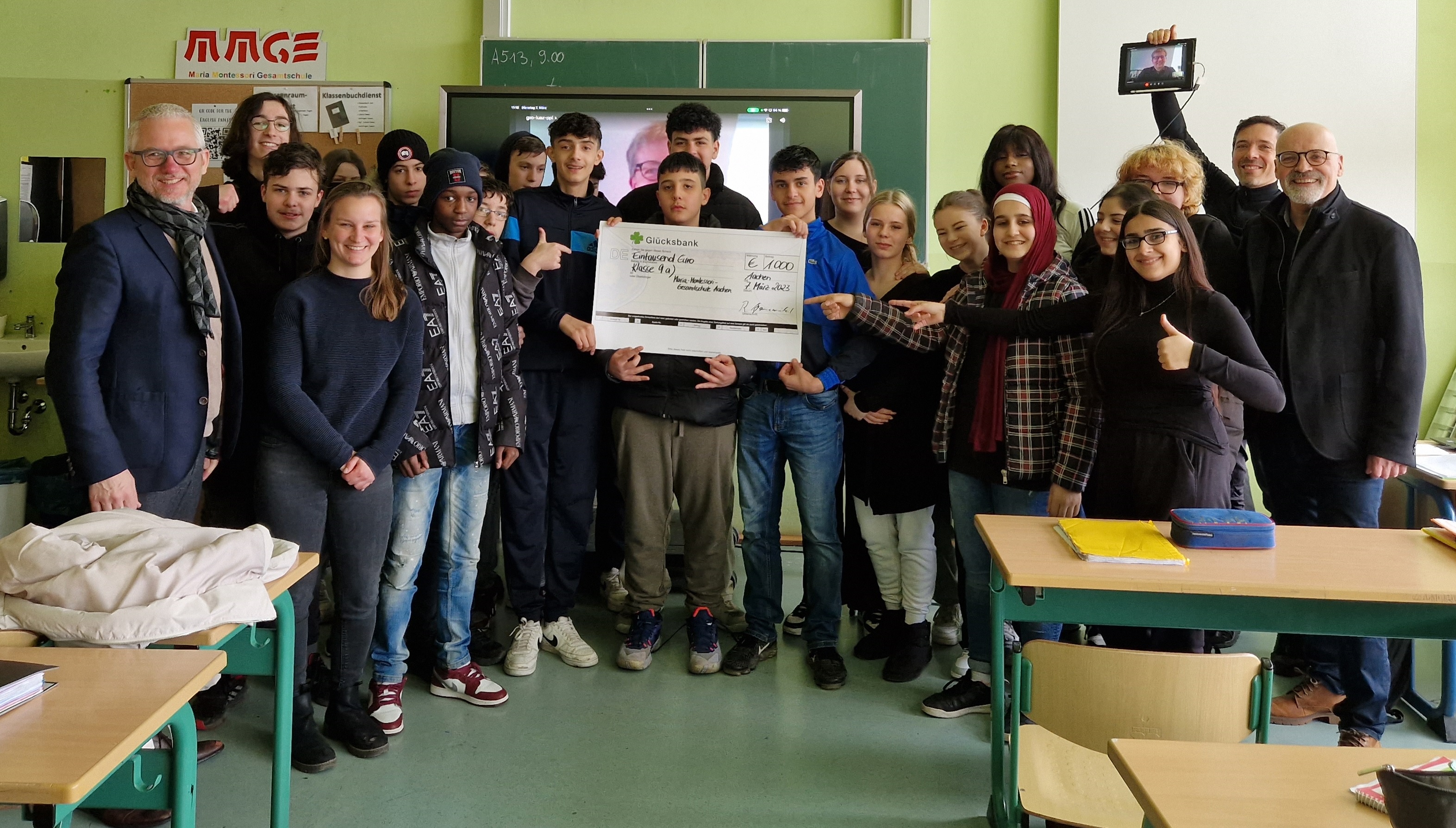 Die glückliche Hauptgewinnerklasse, die 9a der Maria-Montessori-Gesamtschule in Aachen, hat den Preis am 7. März 2023 im Rahmen einer Feier in der Schule 
von Herrn Prof. Dr. Dietrich von der Bundeszentrale für gesundheitliche Aufklärung (ganz links) und Herrn Prof. Dr. Hanewinkel vom Institut für Therapie- und 
Gesundheitsforschung (ganz rechts) verliehen bekommen. Live dazu geschaltet war Herr Burkhard Blienert, der Beauftragter der Bundesregierung für Sucht- und 
Drogenfragen und Schirmherr von klar bleiben.